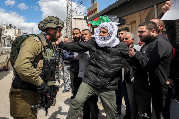 ""فلسطينيون خلال مشادة مع جندي اسرائيلي اثناء احياء ذكرى يوم الارض في بلدة حوارة قرب نابلس