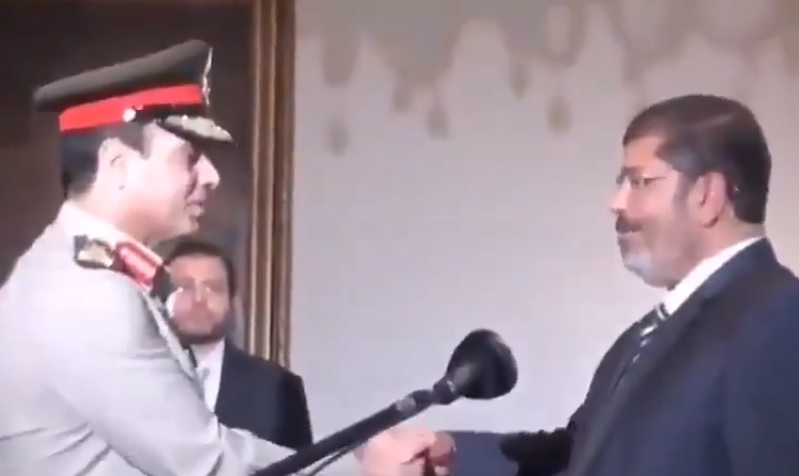 ""محمد مرسي مصافحا الرئيس الحالي عبدالفتاح السيسي بعد اداء الاخير القسم امامه