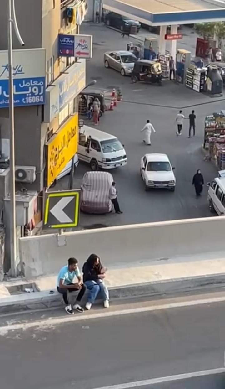 ""لقطة ماخوذة من فيديو الكوبري يظهر الشاب والفتاة فوق الجسر وتحتهما شارع يعج بالمارة