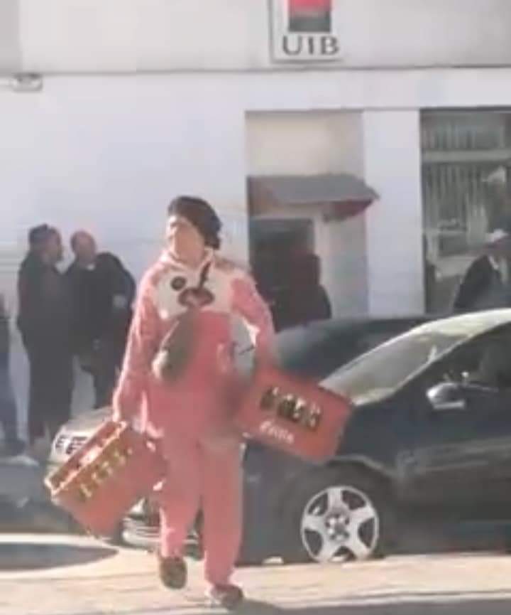 ""امراة تحمل صندوقي بيرة استولت عليهما من الشاحنة 