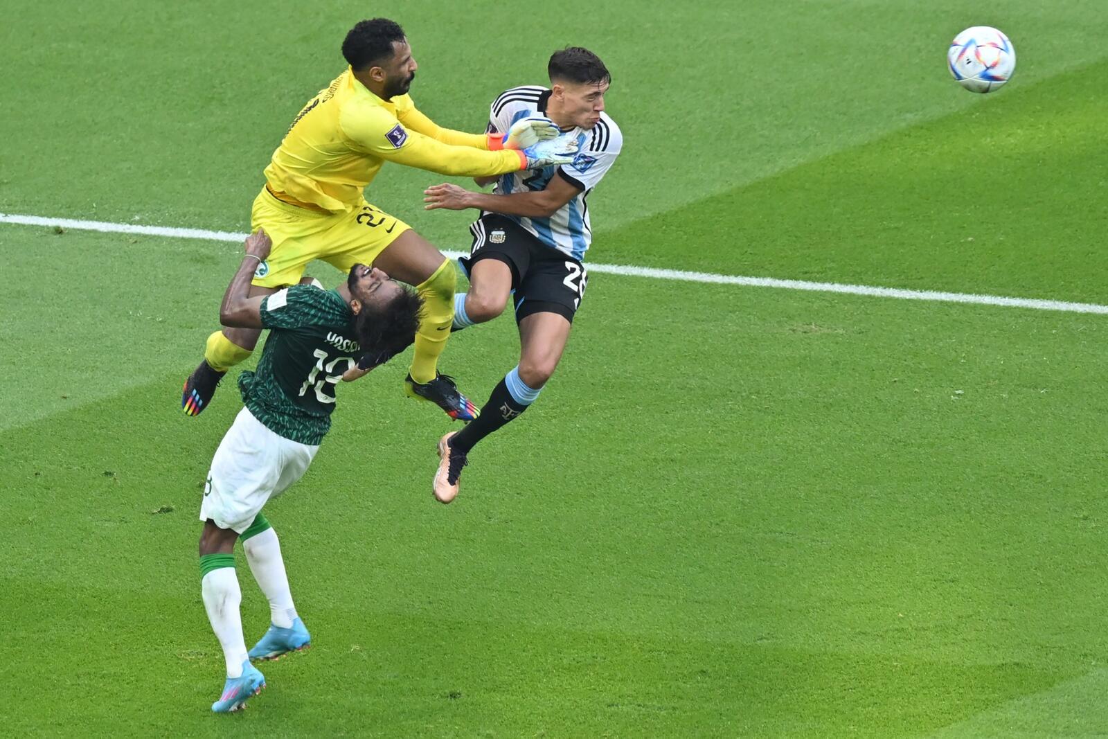 Saudi Arabia's defender #13 Yasser Al-Shahrani collides with Saudi Arabia's goalkeeper #21 Mohammed Al-Owais during the Qatar 2022 World Cup Group C football match between Argentina and Saudi Arabia at the Lusail Stadium in Lusail, north of Doha on November 22, 2022. (Photo by Glyn KIRK / AFP)