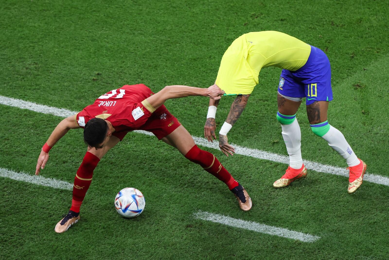 Serbia's midfielder #16 Sasa Lukic grabs Brazil's forward #10 Neymar jersey as they fight for the ball during the Qatar 2022 World Cup Group G football match between Brazil and Serbia at the Lusail Stadium in Lusail, north of Doha on November 24, 2022. (Photo by Giuseppe CACACE / AFP)