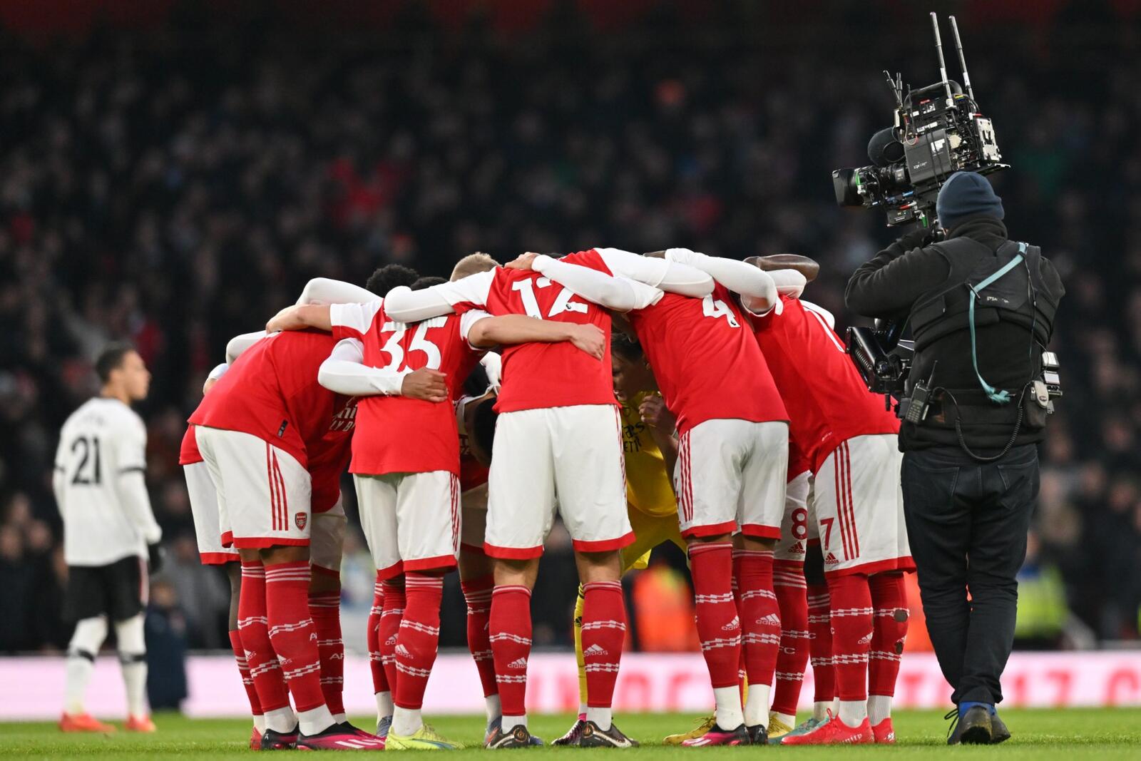 Arsenal players form a group huddle ahead of kick-off in the English Premier League football match between Arsenal and Manchester United at the Emirates Stadium in London on January 22, 2023. (Photo by Glyn KIRK / AFP)