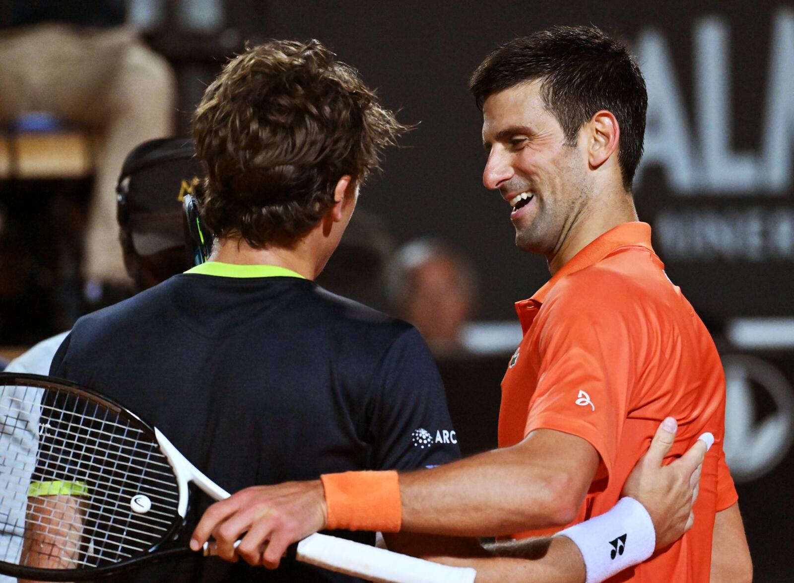 Serbia's Novak Djokovic (R) and Norway's Casper Ruud embrace after Djokovic won their semifinal match at the ATP Rome Open tennis tournament on May 14, 2022 at Foro Italico in Rome. (Photo by Andreas SOLARO / AFP)