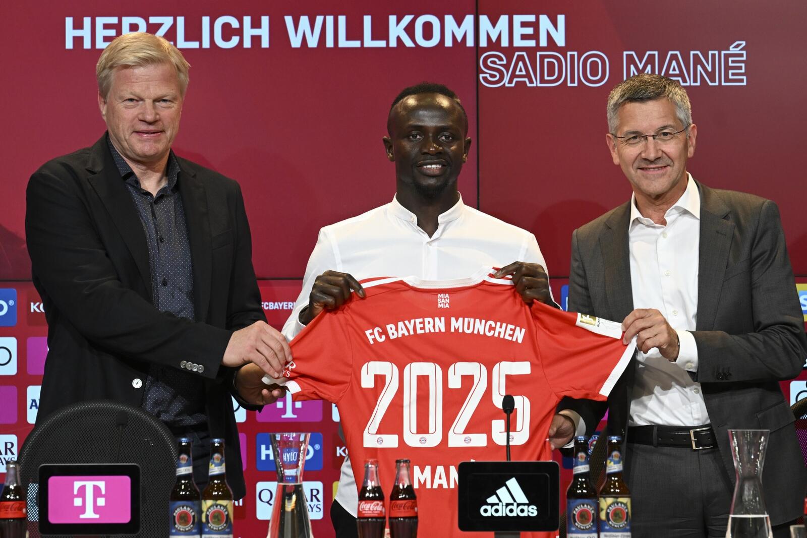 Bayern Munich's Senegalese new forward Sadio Mane (C) with his jersey poses next to Bayern Munich CEO Oliver Kahn (L) and President Herbert Hainer during a press conference after he signed a three-year deal with German first division football club FC Bayern Munich, in Munich, southern Germany, on June 22, 2022. (Photo by CHRISTOF STACHE / AFP)