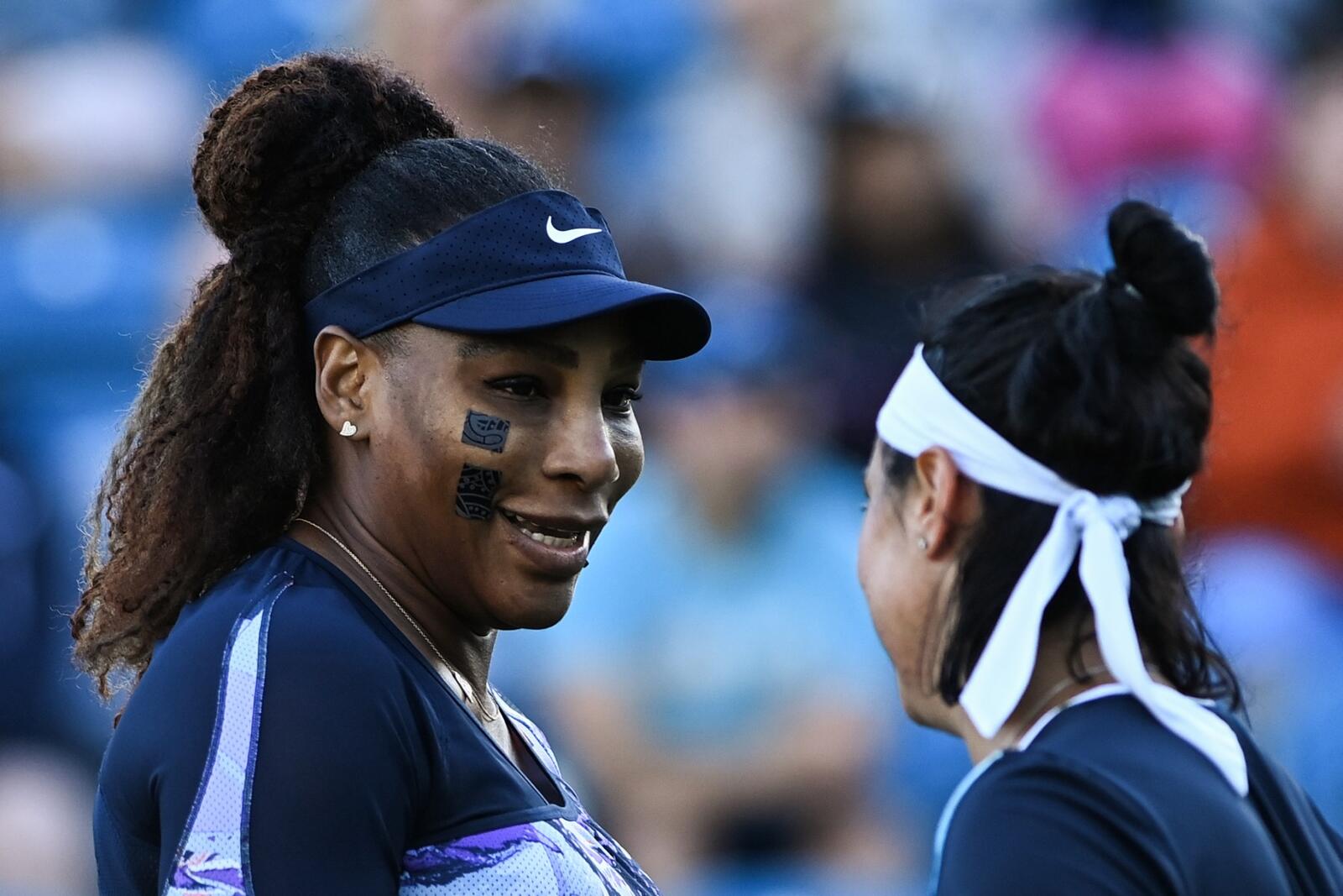Serena Williams of the US (L) and Tunisia's Ons Jabeur react as they play against Japan's Shuko Aoyama and Taiwan's Chan Hao-ching during their women's doubles quarter final tennis match on day four of the Eastbourne International tennis tournament in Eastbourne, southern England on June 22, 2022. (Photo by Glyn KIRK / AFP)