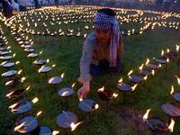 A Cambodian boy lights candles during the Visak Bochea Buddhist celebration at a pagoda in Phnom Penh on May 18, 2019. TANG CHHIN Sothy / AFP