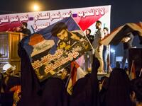 Iraqi followers of Shiite Muslim cleric Moqtada al-Sadr wave national flags and raise protest signs as they demonstrate in the southern city of Basra on May 24, 2019, against involvement in any conflict between Iran and the United States.  Hussein FALEH / AFP