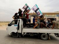 A convoy of Syrians follow the truck carrying the coffin of late rebel fighter Abdel-Basset al-Sarout on June 9, 2019, near the Bab al-Hawa crossing point, northwestern Syria, on the way to his funeral after crossing the border from Turkey where he was receiving treatment following his injury earlier this week. OMAR HAJ KADOUR / AFP