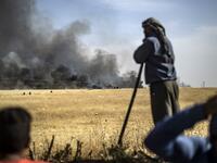 People battle a blaze next to an oil well in an agricultural field in the town of al-Qahtaniyah, in the Hasakeh province near the Syrian-Turkish border on June 10, 2019. Fires have erupted in various parts of Syria in recent weeks, with all sides blaming each other for starting them. Delil souleiman / AFP