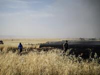People battle a blaze next to an oil well in an agricultural field in the town of al-Qahtaniyah, in the Hasakeh province near the Syrian-Turkish border on June 10, 2019. Fires have erupted in various parts of Syria in recent weeks, with all sides blaming each other for starting them. Delil souleiman / AFP