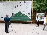 Tourists snap selfies by a bronze statue of the diver who died trying to save the 'Wild Boar' footballers from a flooded cave, while momentos from their rescue fly off the shelves -- scooped up by the 1.3 million people who have descended on a once serene mountainside in northern Thailand. Lillian SUWANRUMPHA / AFP