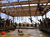 Runners cross an obstacle as they take part in the Mud Day, a 13km race with obstacles in Beynes, near Paris on June 16, 2019.  ALAIN JOCARD / AFP