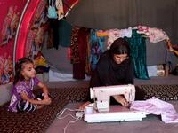 Iraq's Yazidi survivor Layleh Shemmo sews inside her tent in the Khonke camp for displaced persons in northwestern Iraq on June 24, 2019. Working in the Khonke displacement camp in northwest Iraq, Shemmo glances down at the name tattooed on her left hand: Kero, her husband, still missing five years after the Islamic State group rampaged across the Sinjar region. At the time, IS killed Yazidi men en masse, took boys as child soldiers and sold women as "sex slaves," with survivors streaming into shabby displa
