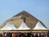 People gather during an inaugural ceremony in front of the Bent pyramid of King Sneferu, the first pharaoh of Egypt's 4th dynasty, in the ancient royal necropolis of Dahshur on the west bank of the Nile River, south of the capital Cairo on July 13, 2019. Mohamed el-Shahed / AFP