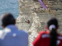 A cliff diver jumps from a platform on the landmark Raouche sea rock off the coast of the Lebanese capital Beirut on July 14, 2019, during the women's 2019 Red Bull Cliff Diving World Series.  ANWAR AMRO / AA / AFP