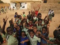 Pupils gesture in front of a mural painting of a protester killed during anti-government protests in the Sudanese capital Khartoum. ASHRAF SHAZLY / AFP
