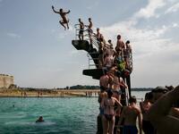People queue to dive into the landmark sea pool of Saint-Malo, Brittany, on July 23, 2019 as a new heatwave blasted into northern Europe that could set records in several countries. Valery HACHE / AFP