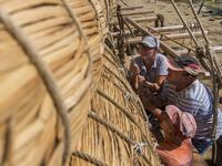 Members of the crew assemble the 14-meter long sailing reed boat Abora IV in the town of Beloslav, Bulgaria, on July 25, 2019. NIKOLAY DOYCHINOV / AFP