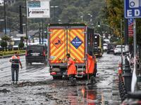 Municipality employees work on the road in Eminonu district, Istanbul, after a heavy rainfall, on August 17, 2019. Turkey's mega city Istanbul was lashed by a heavy rainstorm on August 17, killing a homeless man and leaving parts of the historic Grand Bazaar flooded.  Ozan KOSE / AFP