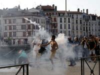 A protester lobs a 'canister' back towards French security personnel during a demonstration in the city of Bayonne, south-west France on August 24, 2019, on the sidelines of the annual G7 Summit. Thomas SAMSON / AFP