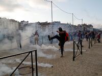 A protester kicks away a 'canister' fired by French security personnel during a demonstration in the city of Bayonne, south-west France on August 24, 2019. Thomas SAMSON / AFP