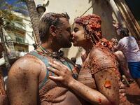 Revellers covered in tomato pulpkiss during the annual "Tomatina" festival in the eastern town of Bunol, on August 28, 2019. JAIME REINA / AFP