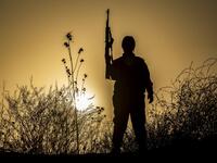 A member of the Bethnahrin Women Protection Forces (HSNB), an all-female Syriac-Assyrian paramilitary group under the umbrella of the Syrian Democratic Forces (SDF), stands holding up a Kalashnikov assault rilfe during a commemoration of the fourth anniversary of their creation, in the countryside of the town of Tall Tamr in the northwestern Syrian province of Hasakah, on August 30, 2019.  Delil SOULEIMAN / AFP