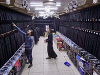 A man browses black garbs sold to Shiite Muslim pilgrims amidst preparations ahead of the Shiite religious mourning period of Ashura, in the central Iraqi holy shrine city of Najaf on August 31, 2019.  Haidar HAMDANI / AFP