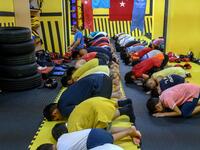 In this photograph taken on August 29, 2019, trainers and children from Muslim Uighur minority pray as they attend a Muay Thai training session in a boxing academy in Istanbul. BULENT KILIC / AFP