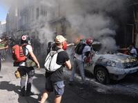 Street medics use a fire extinguishers on a burning French Municipal Police car on the sidelines of an anti-government demonstration called by the "Yellow Vests" (Gilets Jaunes) movement in Montpellier, southern France on September 7, 2019. Pascal GUYOT / AFP