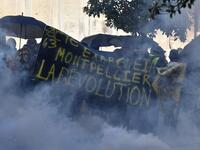 Protesters stand amid smoke from tear gas and behind a banner reading "Montpellier, Hong Kong, the international revolution" during an anti-government demonstration called by the "Yellow Vests" (Gilets Jaunes) movement on September 7, 2019 in Montpellier, southern France. Pascal GUYOT / AFP