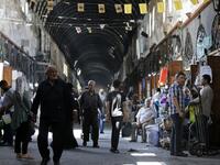 Shoppers walk through the Bzourieh market in the centre of the Syrian capital Damascus. LOUAI BESHARA / AFP