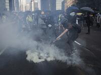 A protester pours water on a tear gas cannister fired by police beside the Admiralty MTR station in Hong Kong on October 1, 2019, as the city observes the National Day holiday to mark the 70th anniversary of communist China's founding. Mark RALSTON / AFP 