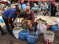 An elderly Palestinian man sell olives at a market during harvest season in Khan Yunis in the southern Gaza Strip on October 6, 2019. SAID KHATIB / AFP