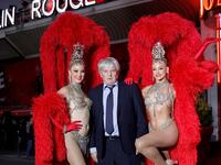 Moulin Rouge cabaret CEO Jean-Jacques Clerico (C) poses with French dancer Mathilde (L) and Australian dancer Rhylee (R) during the celebration of the 130th anniversary of the French oldest cabaret, on October 6, 2019 in Paris.  GEOFFROY VAN DER HASSELT / AFP
