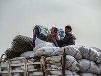 Syrian men flee with their belongings the countryside of the northeastern Syrian town of Ras al-Ain on the Turkish border, toward the west to the town of Tal Tamr on October 19, 2019. Turkey's President Recep Tayyip Erdogan fired off a fresh warning today to "crush" Kurdish forces as both sides traded accusations of violating a US-brokered truce deal in northeastern Syria. Delil SOULEIMAN / AFP