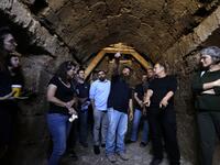 Binyamin Storchan (C), an archaeologist with the Israel Antiquities Authority, shows on October 23 2019 an ancient church crypt in the Israeli city of Bet Shemesh. A magnificent 1500-year-old church, decorated with spectacular mosaic floors and Greek inscriptions, was discovered during a three-year excavation near a residential area. MENAHEM KAHANA / afp