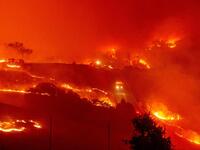 Fire trucks navigate roads surrounded with fire as wind and embers rip through the area during the Kincade fire near Geyserville, California. (Photo by Josh Edelson / AFP)