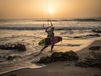 A picture taken on October 10, 2019, shows a kitesurfer holding her kite as she walks away at Dakhla beach in Morocco-administered Western Sahara. In the heart of disputed Western Sahara, a former garrison town has become an unlikely tourist magnet after kitesurfers discovered the windswept desert coast on the Atlantic is perfect for their sport. FADEL SENNA / AFP