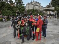 Venezuelan migrant Johnny Tales (C-bottom), who makes a living imitating the comicbook and film character "The Joker", pose with fellow compatriots also fancy dressed as comic and film industry characters in downtown Medellin, on October 29, 2019. JOAQUIN SARMIENTO / AFP