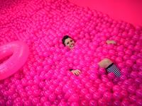 A woman smiles, while lying in a ball bath, at the "Supercandy Pop-Up Museum Vol. 2" in Cologne, western Germany on November 1, 2019. It is an interactive museum and offers a photo backdrop for social media at 25 stations. INA FASSBENDER / AFP