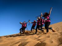 Women run down a sand dune as they take part in the desert trek "Rose Trip Maroc", on November 4, 2019 in the erg Chebbi near Merzouga. The Rose Trip Maroc is a female-oriented trek where teams of three must travel through the southern Moroccan Sahara desert with a compass, a map and a topographical reporter. JEAN-PHILIPPE KSIAZEK / AFP