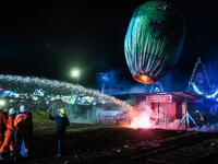 This picture taken on November 4, 2019 shows firefighters at work after a fireworks-laden hot-air balloon ignited before the balloon was at a sufficient height during during the Tazaungdaing Lighting Festival at Taunggyi in Myanmar's northeastern Shan State. Brightly coloured balloons with hundreds of homemade fireworks woven into their frames are sent soaring into the night sky, showering down cascades of sparks onto adoring crowds in the annual Taunggyi fire balloon festival. Ye Aung THU / AFP