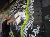 Graffiti artist Mohammad Abrashh draws a graffiti on the wall of a building at the al-Nour Square in the northern port city of Tripoli on November 7, 2019. An unprecedented protest movement has gripped Lebanon since October 17, demanding an overhaul of a political class that has remained largely unchanged since the end of the country's 1975-1990 civil war. In the northern city of Tripoli, where mobilisation has been relentless since the protests erupted on October 17, demonstrators took down politicians' po