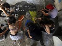 Lebanese anti-government protesters paint a graffiti on the ground in central Beirut on November 5, 2019. Since October 17, the chanting of tens of thousands of Lebanese denouncing the political elite have shaken the normally staid district around two Beirut squares, Martyrs' and Riad Al Solh. JOSEPH EID / AFP