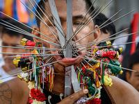 AFP PICTURES OF THE YEAR 2019 - A devotee of a Chinese shrine with multiple skewers pierced through his cheeks takes part in a procession during the annual Vegetarian Festival in Phuket on October 3, 2019. The festival begins on the first evening of the ninth lunar month and lasts for nine days, with many religious devotees slashing themselves with swords, piercing their cheeks with sharp objects and committing other painful acts to purify themselves, taking on the sins of the community. Mladen ANTONOV / AF