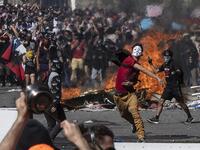 People demonstrate at Plaza Italia on the fifth straight day of street violence which erupted over a now suspended hike in metro ticket prices, in Santiago on October 22, 2019. President Sebastian Pinera convened a meeting with leaders of Chile's political parties on Tuesday in the hope of finding a way to end street violence that has claimed 15 lives, as anti-government campaigners threatened new protests. Pedro UGARTE / AFP