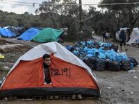 A man peers outside his tent at the makeshift camp next to the overcrowded refugee camp of Moria near the capital Mytilene in the island of Lesbos on November 29, 2019. ARIS MESSINIS / AFP