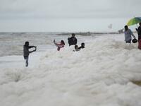 Residents take selfie pictures as foamy discharge, caused by pollutants, mix with surf at Marina beach in Chennai on December 1, 2019. Arun SANKAR / AFP
